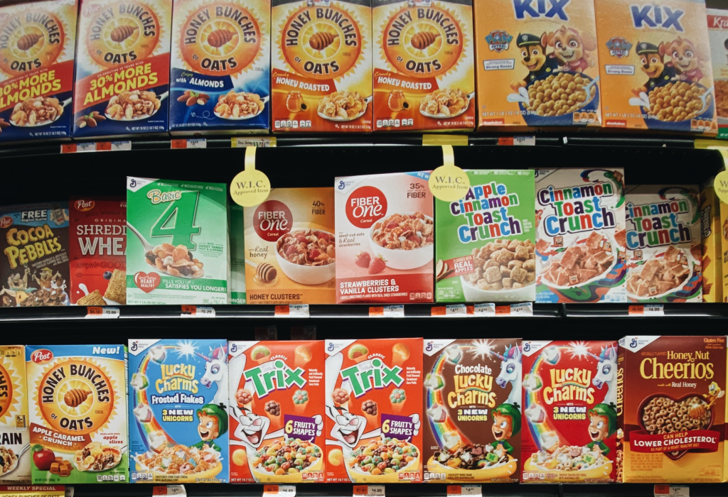 simple carbohydrates: sugary cereal boxes on supermartket shelves